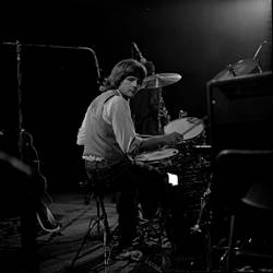 A person playing drums on a stage

Description automatically generated