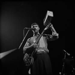 A person holding a guitar and a box

Description automatically generated